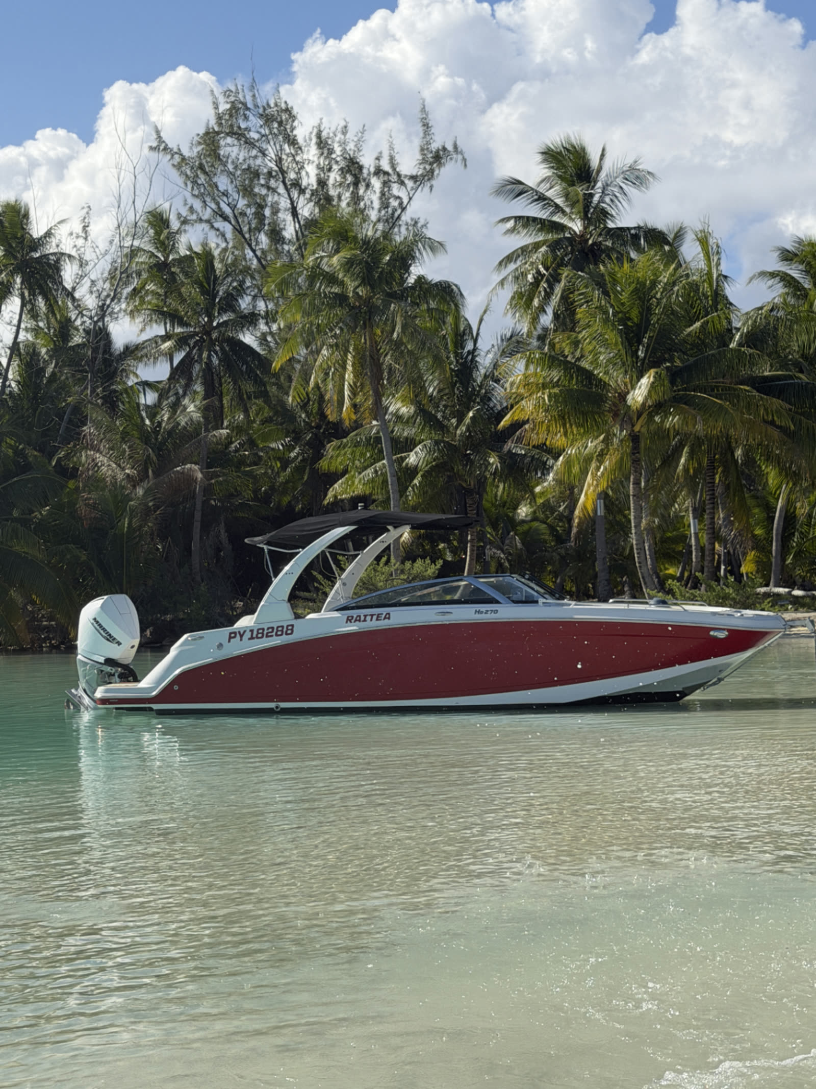 Four Winns HD 270 OB rouge et blanc devant les cocotiers de Fakarava
